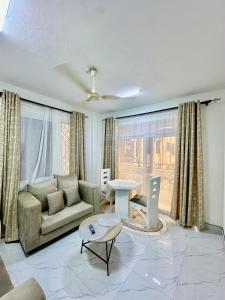 モンバサにあるHarmony 1 Bedroom Apartmentのソファとテーブルのあるリビングルーム