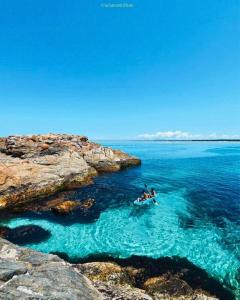 a group of people in a boat in the water at Pé na areia, Prainha in Arraial do Cabo