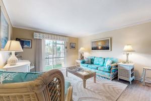 un soggiorno con un divano blu e un tavolo di Cozy condo with balcony, walking distance to conch house and WIFI a Davis Shores