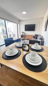 a table with plates and bowls on it in a living room at Miraflores Deluxe in Lima +4 photos