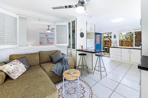a living room with a couch and a kitchen at Tiny Comfy flat with Bikes in Coolum Beach