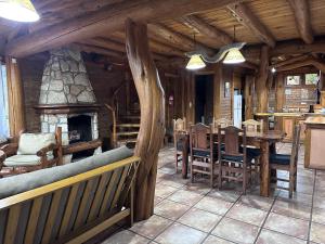 a living room with a fireplace and a table and chairs at Cabañas Las Nubes in San Carlos de Bariloche