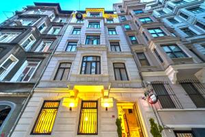 イスタンブールにあるホテル ネクスト 2の黄色のドアと窓が特徴の白い高い建物
