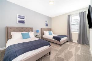 a bedroom with two beds and a window at Wonderful Disney-Themed Home in ChampionsGate Resort 15 min from Disney World with 7 pools, Club houses, Water Park, Gym, Arcades, Lazy River, Golf, and More! in Kissimmee