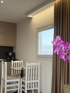 a kitchen with a table and chairs and a window at Eri Apartments in Durrës