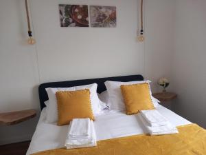 a bed with white sheets and yellow pillows at Alto do Sossego in Nordeste