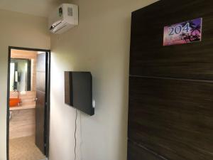 a room with a door with a television on the wall at Hotel Raquel Rosado in Fonseca