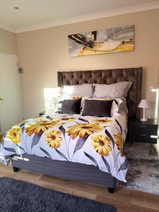 a bedroom with a bed with yellow flowers on it at Cape Golf Villa in Cape Town +36 photos