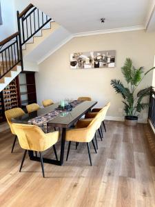 a dining room with a black table and chairs at Cape Golf Villa in Cape Town