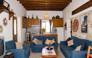 a living room with blue couches and a kitchen at Narkissos Villa in Kallepia