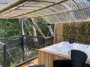 a bathroom with a tub in a greenhouse at Glamping A-MAR in Cocorná