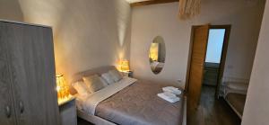 a bedroom with a bed with two lamps and a mirror at OIKOS Guesthouse & Rooftop in Suio