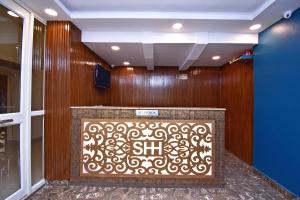 a lobby with a wooden wall with a sign on it at Hotel O Stay hub park street in Kolkata