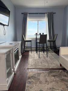 a living room with a table and chairs and a window at Ocean View Cozy Stay 3 in Hull +1 photo
