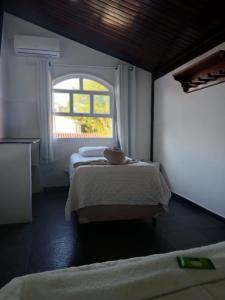 a room with two beds and a window at Pousada Recanto da Luísa in Paraty