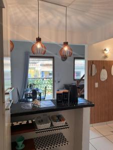 a kitchen with a black counter top with lights at Casa de Mainha Arraial in Arraial d'Ajuda