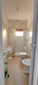a bathroom with two toilets and two sinks and a shower at aMARE21, moderno 2 camere con terrazza privata vista mare in Torre San Gennaro