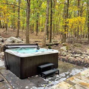 ein Whirlpool mitten im Wald in der Unterkunft Twin Pines Retreat Hot Tub Theater Room Fire in East Stroudsburg