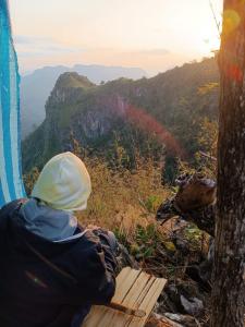 a person sitting on a bench on top of a mountain at Nongkhiaw Camping on mountain with White Rabbit tours in Ban Pho Touane