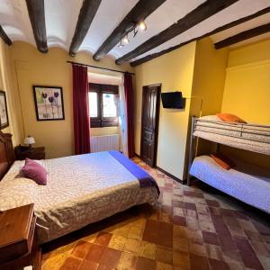due letti in una stanza con pareti gialle di Posada Abadia de Sietamo a Siétamo