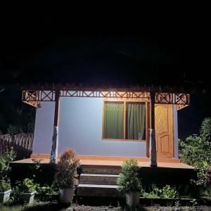 a small white house with a door and some plants at Pondok Gede Semu in Surelage +6 photos