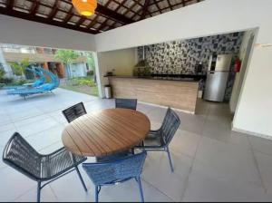 a wooden table and chairs in a living room at Village itacimirim completo in Camacari