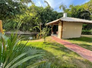 a small building next to a body of water at Village itacimirim completo in Camacari
