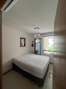 a bedroom with a bed in a room with a window at Village itacimirim completo in Camacari +20 photos