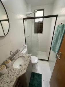 a bathroom with a sink and a toilet and a shower at Village itacimirim completo in Camacari