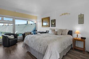a bedroom with a bed and a chair and a window at The Tides by the Sea in Seaside