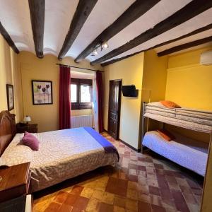 due letti in una stanza con pareti gialle di Posada Abadia de Sietamo a Siétamo