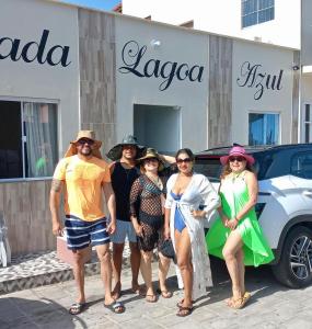 Un grupo de personas de pie frente a una tienda en Pousada lagoa azul, en Santo Amaro
