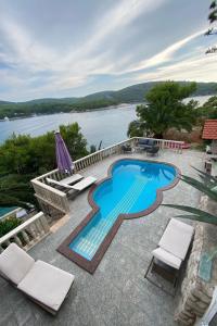 a swimming pool with chairs and a view of the water at Seaside apartments with a swimming pool Cove Pribinja, Hvar - 24171 in Hvar