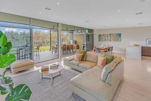 a living room with a couch and a table and a kitchen at Perricoota Waters - Echuca Holiday Homes in Moama