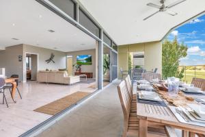 a dining room and living room with a table and chairs at Perricoota Waters - Echuca Holiday Homes in Moama