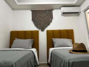 une chambre avec deux lits et un chapeau sur une table dans l'établissement Beach Haus-Punta Estrella, à Playa del Carmen 66 autres photos