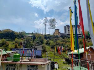a group of flags on a hill with buildings at Edenla homestay in Lachen