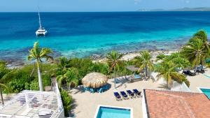 - une vue sur la plage avec un bateau dans l'eau dans l'établissement Crown Ridge 12 Oceanfront, Pool, Near Dive Sites, à Kralendijk
