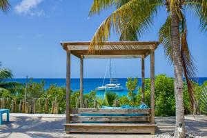 un gazebo sur la plage avec un bateau dans l'établissement Crown Ridge 12 Oceanfront, Pool, Near Dive Sites, à Kralendijk 3 autres photos
