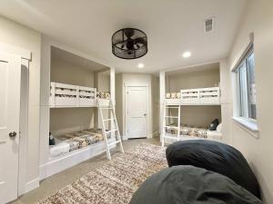 Zimmer mit 3 Etagenbetten und einem Sofa in der Unterkunft Lux Kanab Home with Pool Hot Tub Pickleball Courts in Kanab