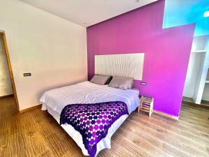 a bed in a room with a pink wall at Villa - Dar Tura in Tikoutar +27 photos