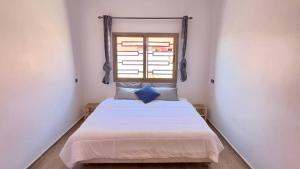 a bedroom with a large bed with a window at Villa - Dar Tura in Tikoutar