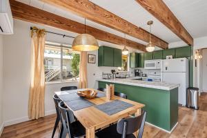cocina y comedor con armarios verdes y mesa de madera en Marina Beach Cabin - Dog-Friendly Home with Deck! home, en Groveland 37 fotos más