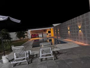 due sedie e una piscina di notte di Casa no Forte Orange a Vila Velha Altre 7 foto