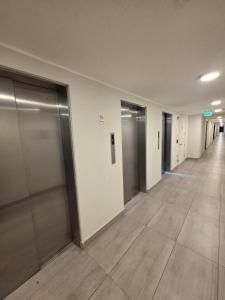 an empty hallway of an office building with elevator doors at Departamento en Santiago, Parque O'higgins, Movistar Arena con terraza in Santiago