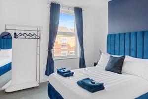 a bedroom with a bed with two blue towels on it at The Navy Nest Luxury Home Nottingham in Nottingham