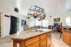 a kitchen with a sink and a living room at El Tranquillo in Templeton
