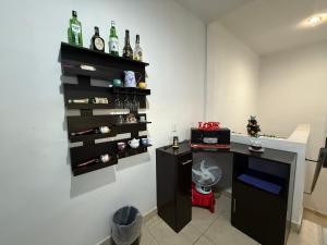 a room with a shelf with bottles on the wall at Estudio Luxury Room in Chetumal
