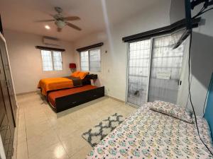 a bedroom with two beds and a ceiling fan at Estudio Luxury Room in Chetumal