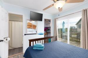 a bedroom with a blue bed and a large window at Paradise between ocean and sound -A Writers Reef in North Topsail Beach